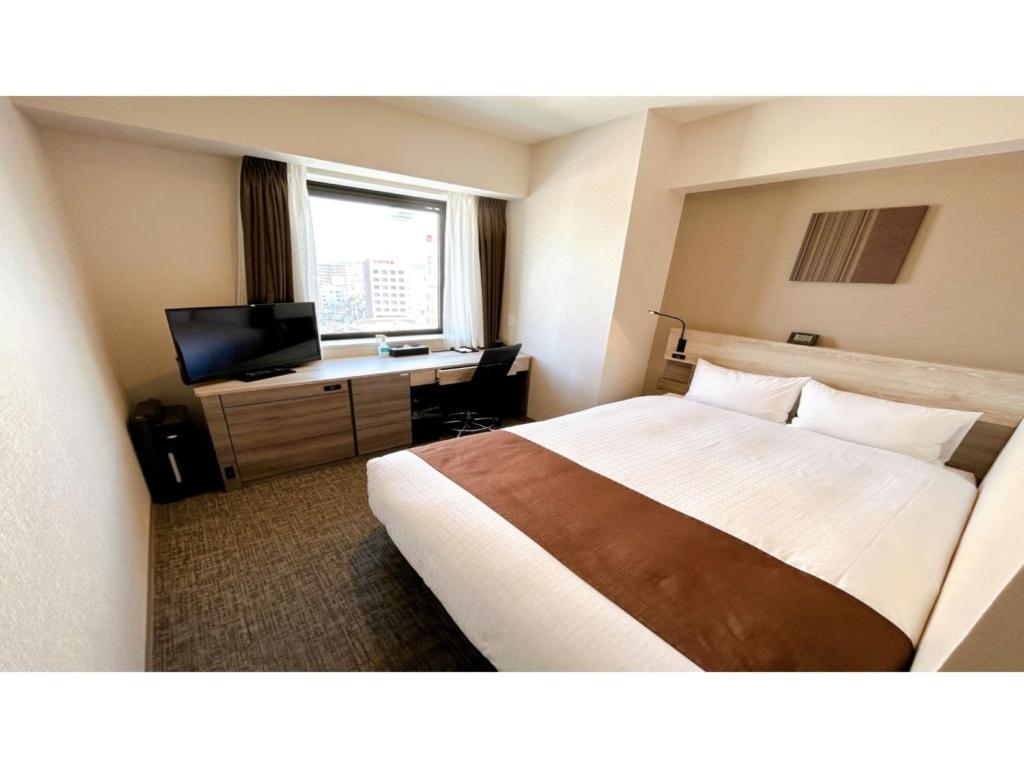 a hotel room with a bed and a desk at Smile Hotel Premium Hakodate Goryokaku - Vacation STAY 97562v in Hakodate