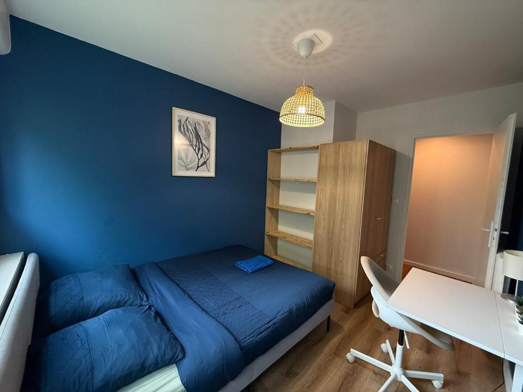 a blue bedroom with a bed and a desk at Spacious 4 bedroom family home 5 min from Caen in Hérouville-Saint-Clair