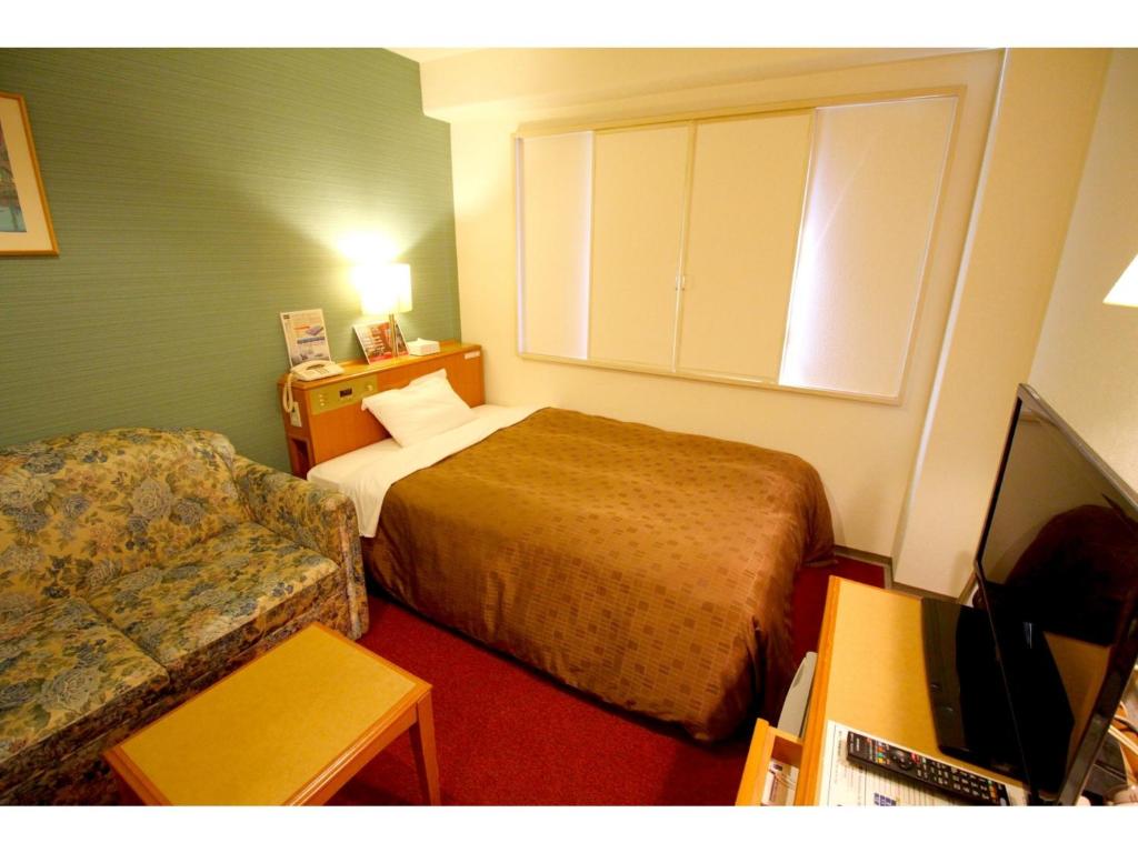 a hotel room with a bed and a couch at Smile Hotel Tokyo Shinkoiwa - Vacation STAY 82180v in Tokyo