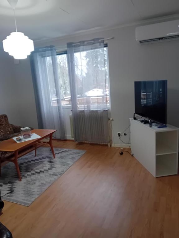 a living room with a table and a television at Forestline Camp 