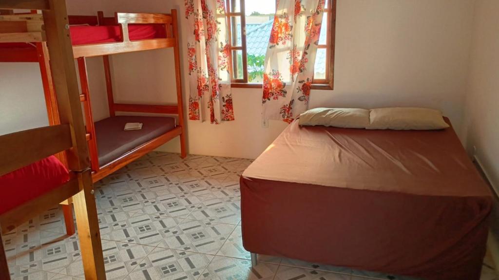 アハイアウ・ド・カボにあるArraial do Cabo casa SOBRADO com piscina entre o Mar e a Lagoa em Cond Villaggio Valtellinaの二段ベッド2台と窓のある寝室