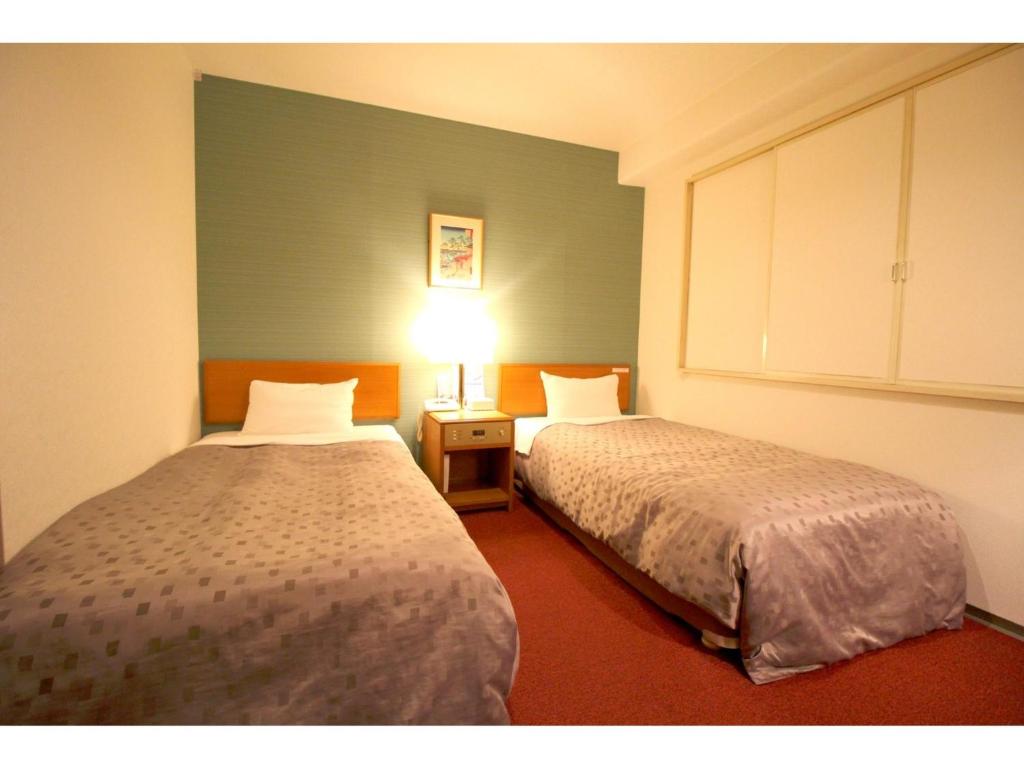 東京にあるSmile Hotel Tokyo Shinkoiwa - Vacation STAY 82190vのベッド2台とランプが備わる部屋