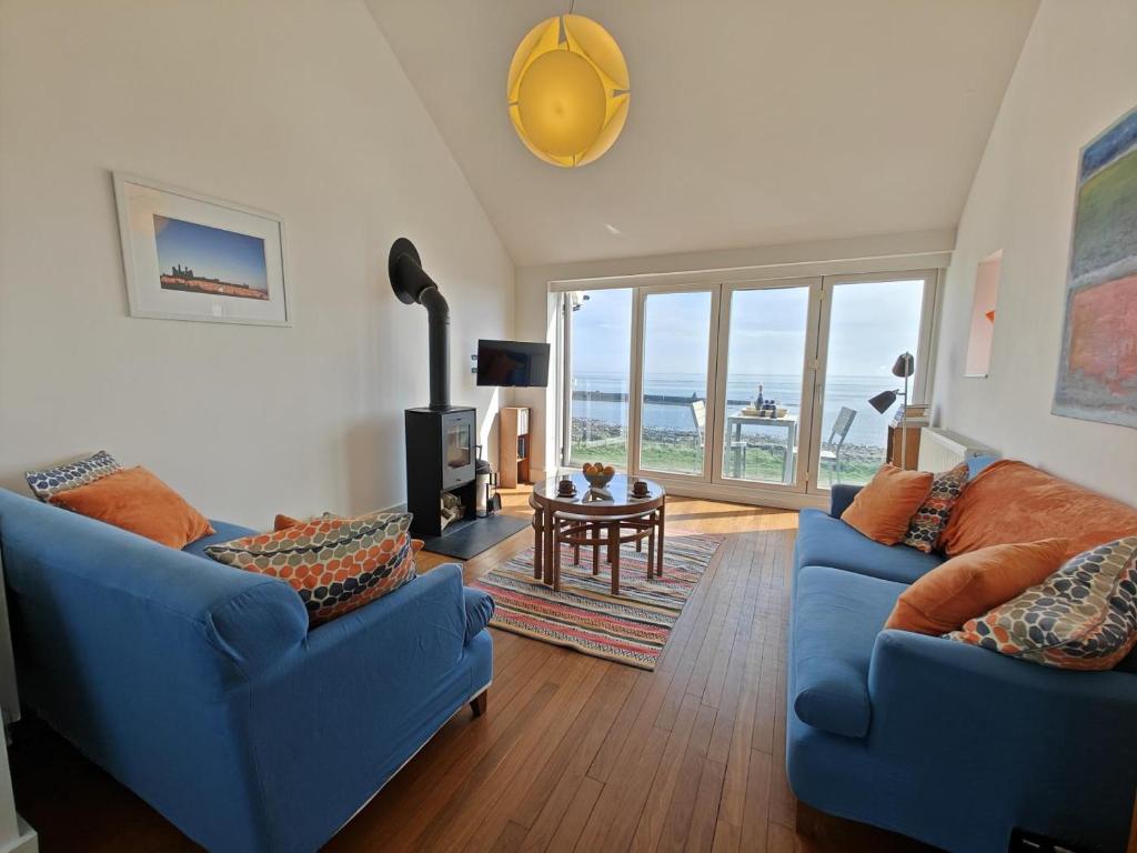 a living room with two blue couches and a table at 2 Bed in Craster oc-c25099 in Craster
