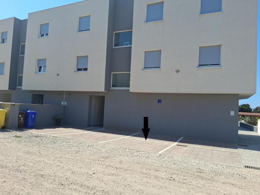 a large white building with a parking lot at Apartman Zeljka in Pula