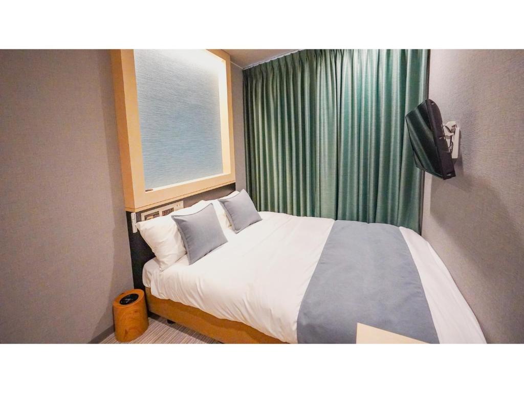 大阪市にあるTHE GALA HOTEL UMEDA - Vacation STAY 24223vの窓のある白いベッドのある寝室