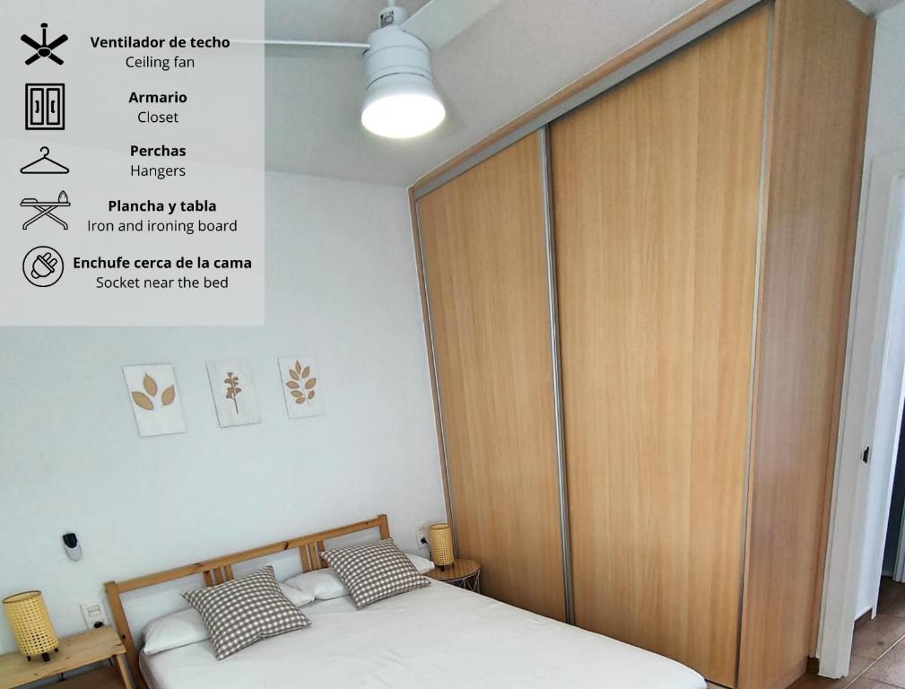Schlafzimmer mit einem Bett und einem Holzschrank in der Unterkunft La Casita de Vera in Playas de Vera