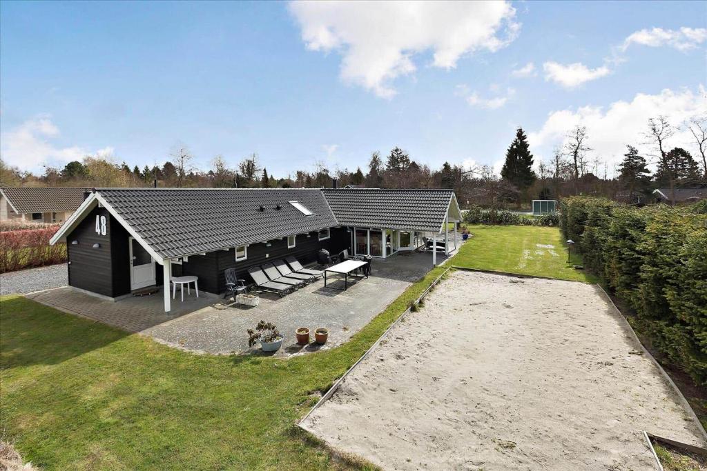 a black house with a patio and a yard at M187-Vaeggerlose-Baeverstien-48 in Marielyst