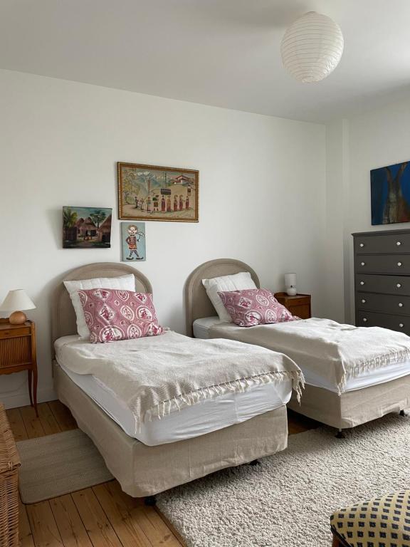 - 2 lits avec des oreillers roses dans une chambre dans l'établissement ancienne poste de Saint coulomb, à Saint-Coulomb