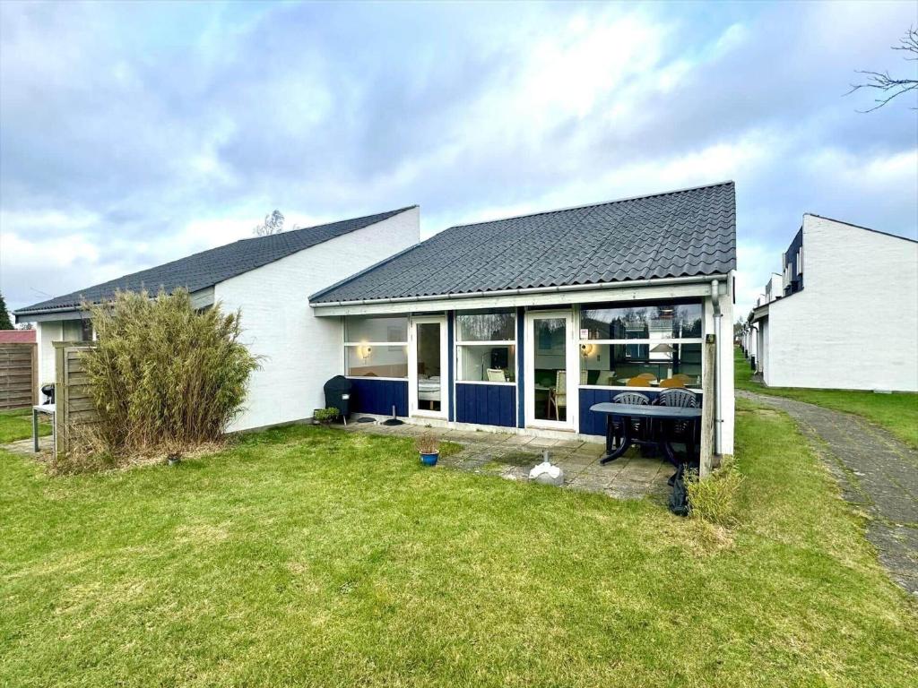 a white house with a table in a yard at M358-Vaeggerlose-Norrevang-38 in Bøtø By