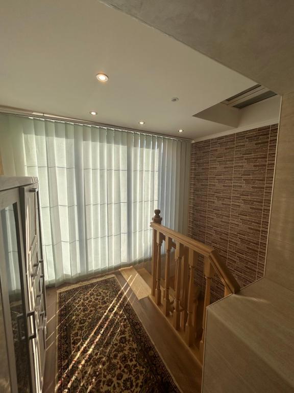 Una habitación con una escalera y una gran ventana. en Girasole, en Chişinău