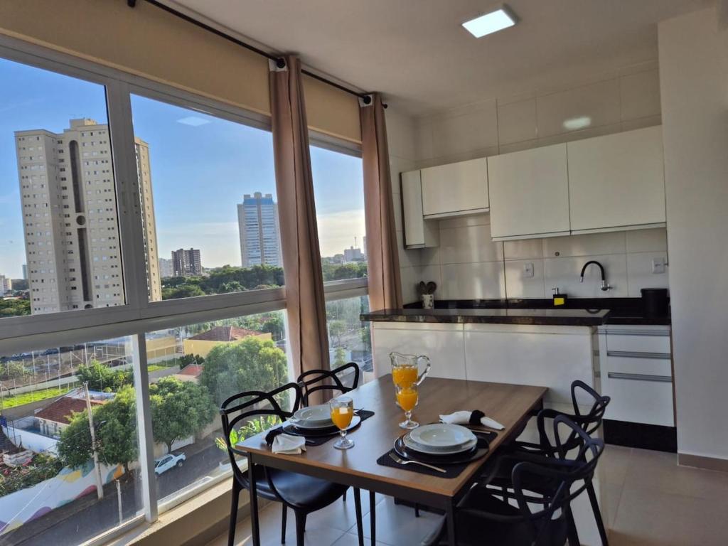 a kitchen with a table and chairs and a large window at Studio 68 Completo com Garagem - Araçatuba-SP in Araçatuba