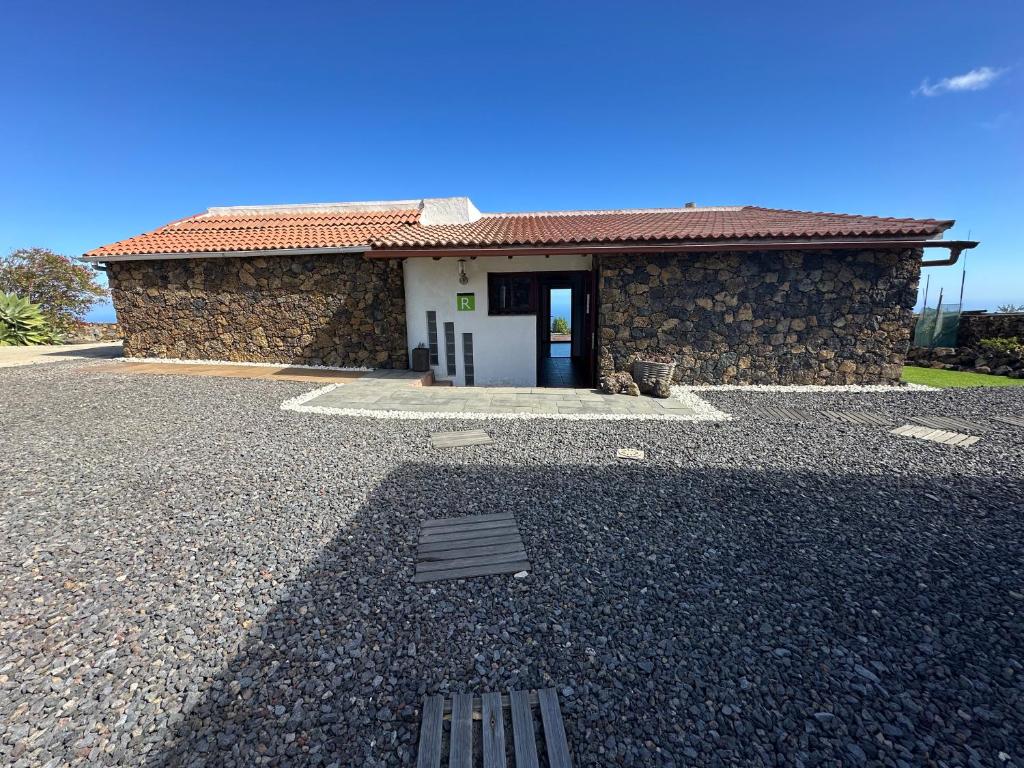 a house with a stone building with a door at La Casa del Risco in El Pinar del Hierro