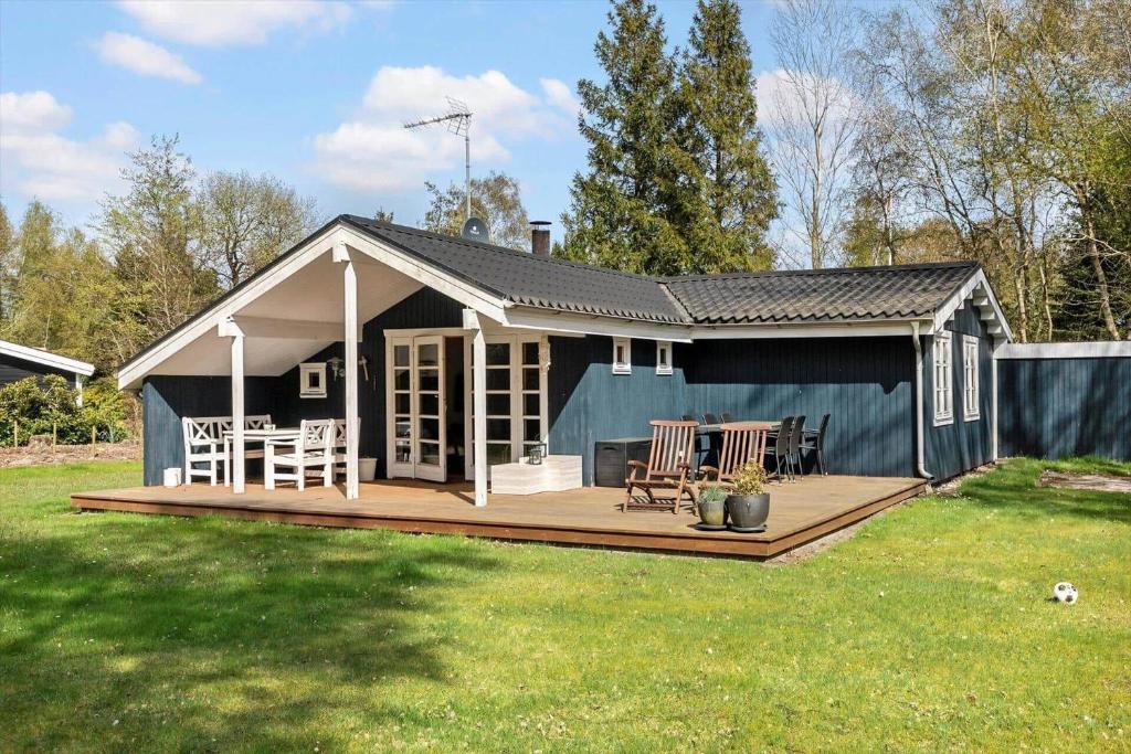 a small blue house with a deck in a yard at M370-Vaeggerlose-Boto-Ringvej-22 in Bøtø By