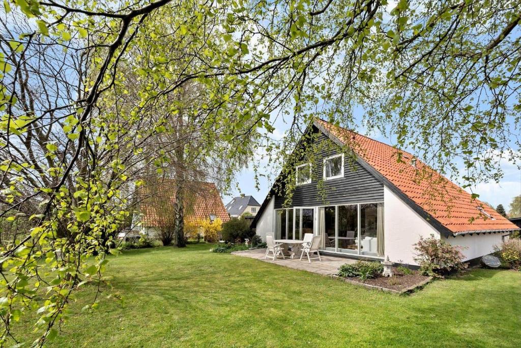 ein weißes Haus mit einem roten Dach und einem Hof in der Unterkunft M374 Gedser - Birkevej 3 in Gedser