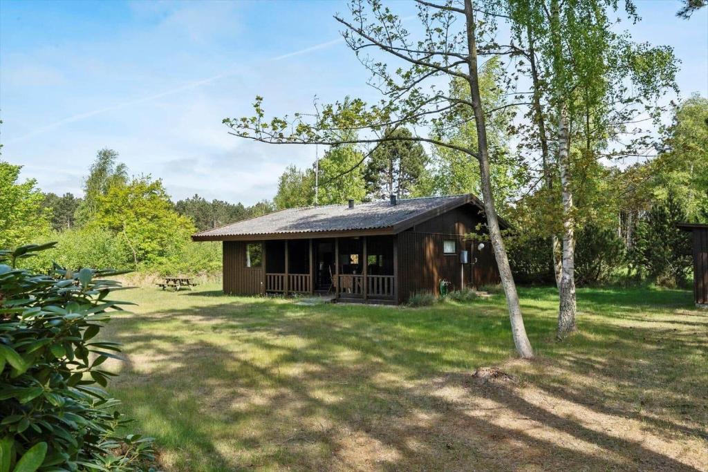 eine kleine Hütte in einem Garten mit einem Baum in der Unterkunft L38 Rødby - Lærkevænget 10 in Rødby
