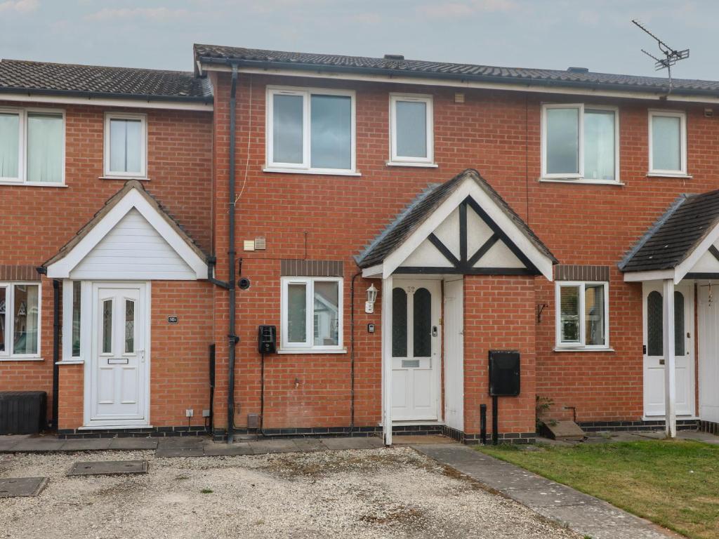 una casa de ladrillo rojo con puertas blancas en 32 Moorland House, en Leicester