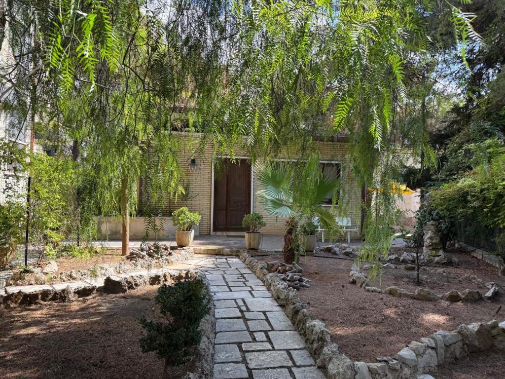 a garden with a stone walkway and a building at villa raffaela lido silvana marina di pulsano fatamorgana in Pulsano