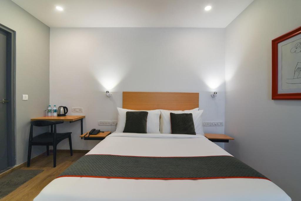 a hotel room with a bed and a desk at Super Townhouse Spruce Hotels Bellandur in Bengaluru