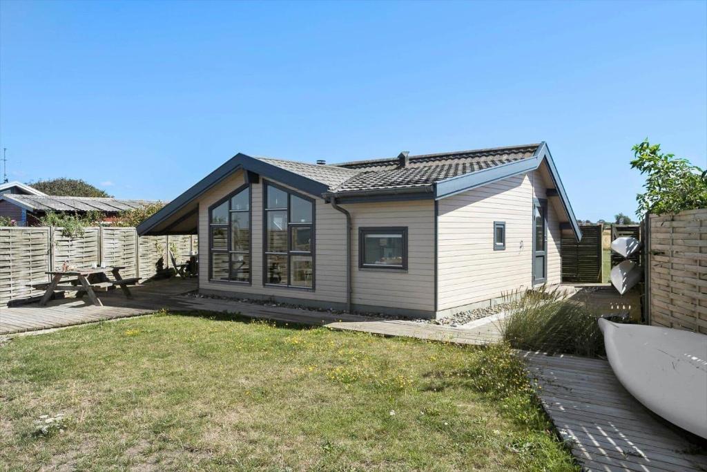 ein kleines Haus in einem Hof neben einem Zaun in der Unterkunft SL261 Korsør - Svenstrup Strandvej 109 in Korsør