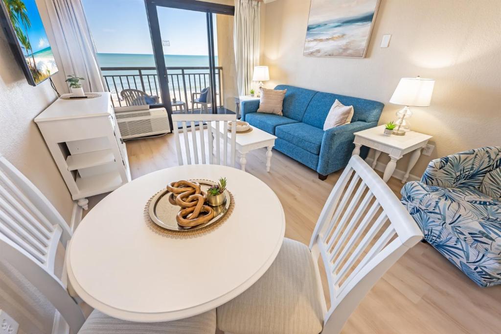 a living room with a white table and chairs at Direct Ocean Front, The Pavilion, Pools, Boardwalk in Myrtle Beach