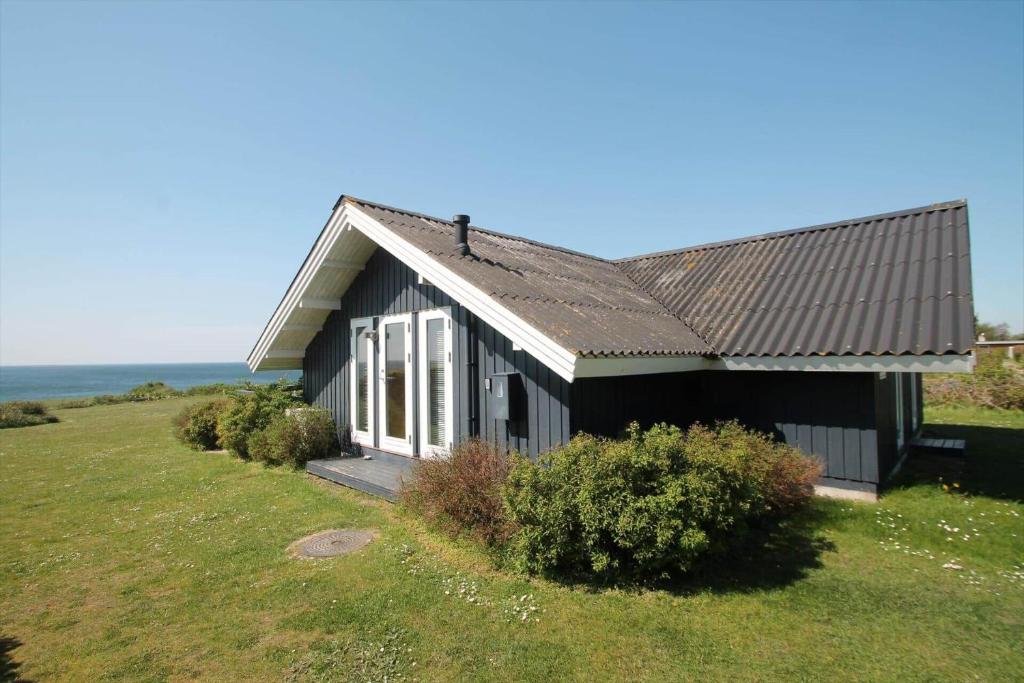 une maison noire assise au-dessus d'un champ dans l'établissement SL308-Slagelse-Jarlsvej-23, à Slagelse