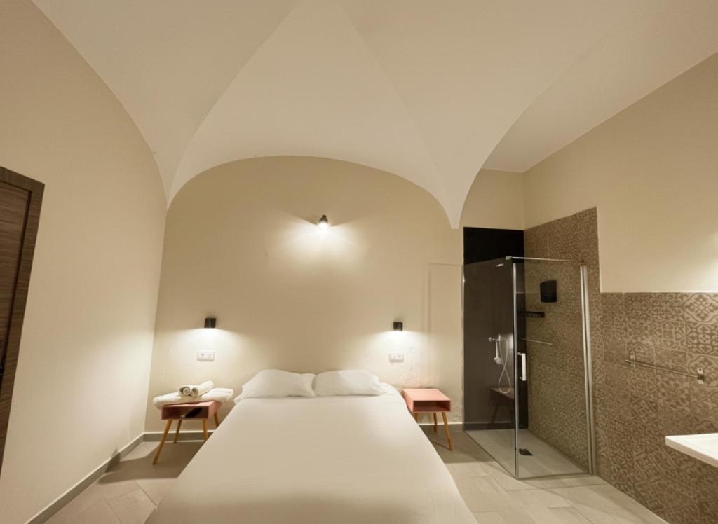 a bedroom with a white bed and a shower at Hostal Pompeya Merida in Mérida