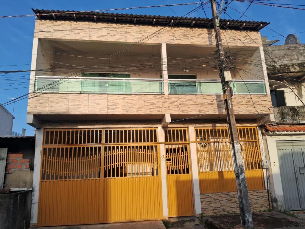 a house with a yellow gate in front of it at Casa para COP30 in Belém