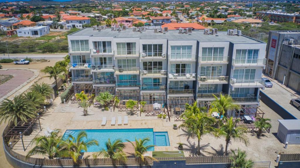 an aerial view of a large building with a swimming pool at 3-Suite Condo Steps to Palm Beach in Palm-Eagle Beach