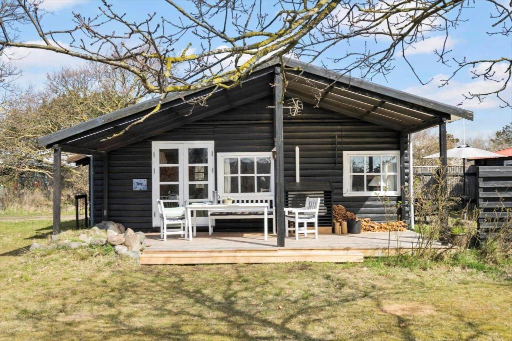 a cabin with a table and chairs on a deck at SL243-Skaelskor-Hybenvej-30 in Skælskør