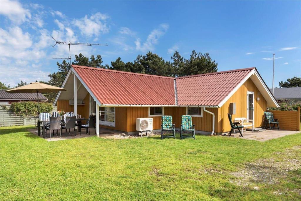 a yellow house with chairs and a yard at K20031-Kalundborg-Kystagervej-29 in Kalundborg
