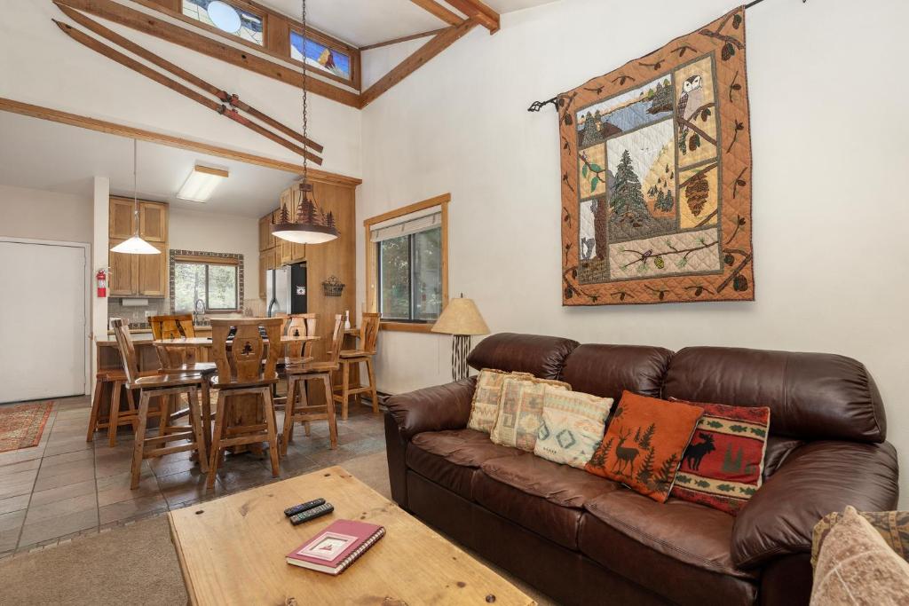 a living room with a brown leather couch and a table at Beaver Village Unit #0131 in Winter Park