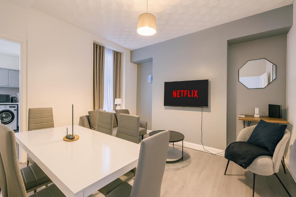 a dining room with a white table and chairs at Stunning 5 Bedroom Home in the Heart of Swansea - Snooker Table, WiFi & Parking! in Swansea