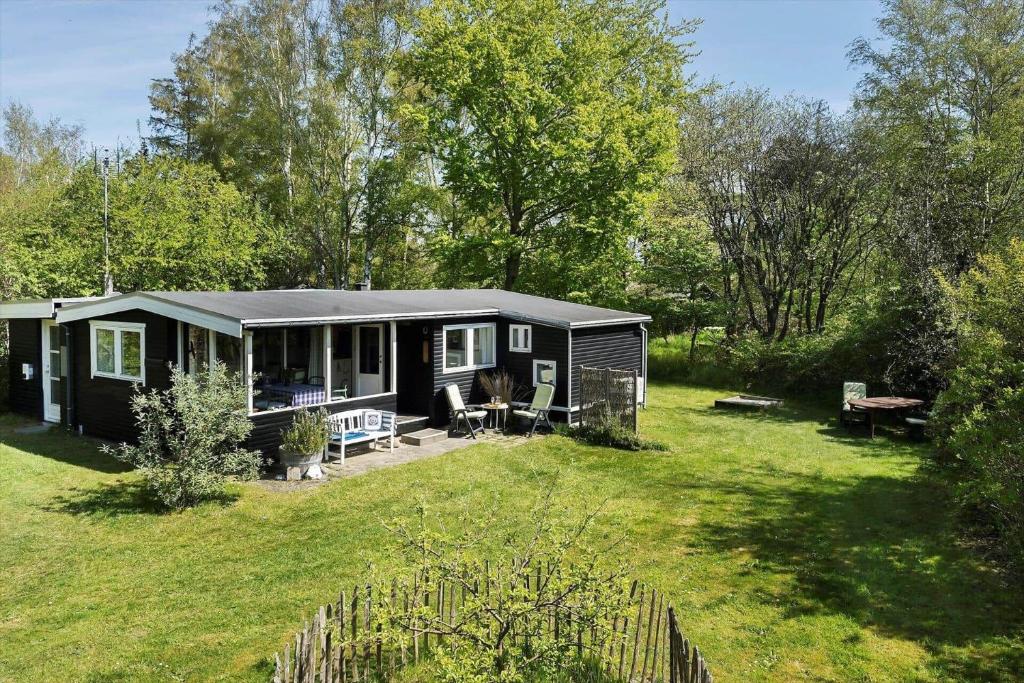 a black tiny house in the middle of a yard at 20399-Samso-Laerkevej-24 in Nordby