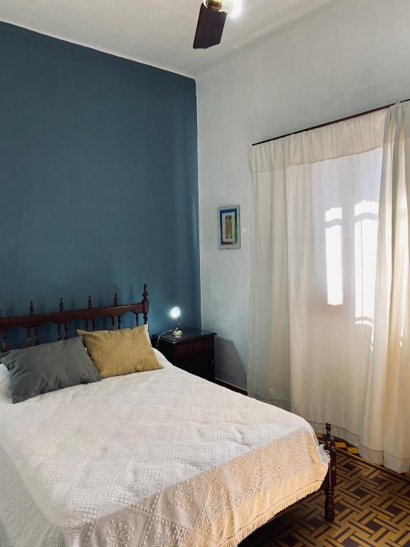 una camera da letto blu con un letto e una finestra di La Reina a Concordia