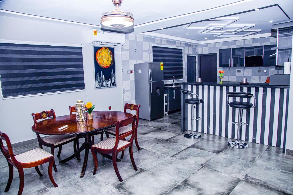 une salle à manger avec une table et des chaises et une cuisine dans l'établissement PEK Villa, Cozy Luxury Hideouts, 25 mins from Airport, à North Legon