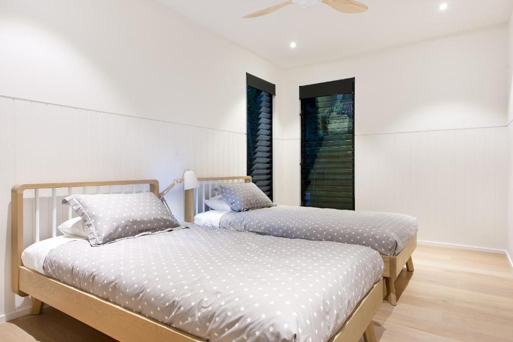 2 Betten in einem Zimmer mit weißen Wänden in der Unterkunft Luxury rainforest retreat, Little Cove in Noosa Heads