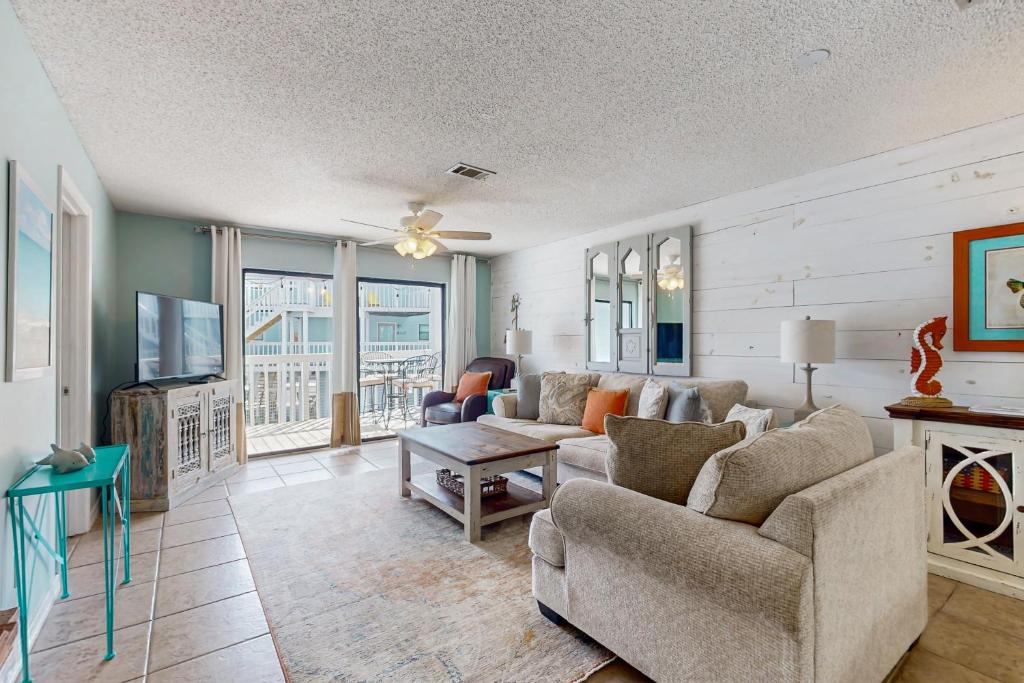 Una sala de estar con un sofá y un televisor. en Bayview 67, en Orange Beach