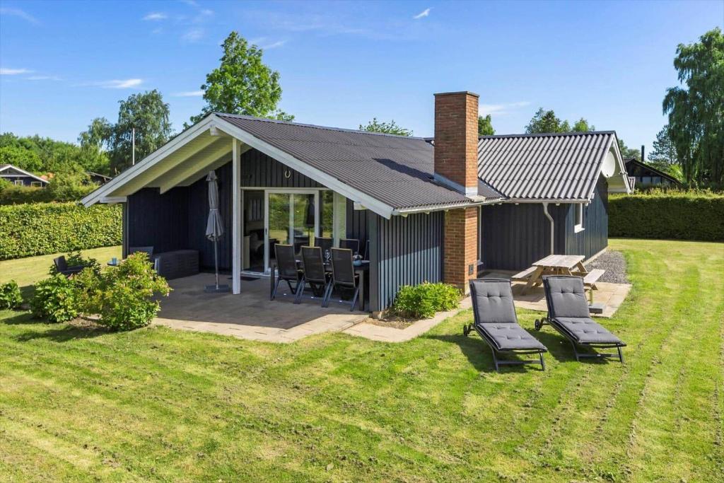 a small house with chairs and a patio at SB102-Sydals-Laerkemose-18 in Neder Lysabild