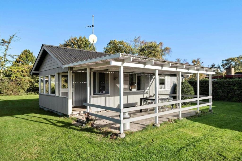 a white house with a porch on a lawn at SB50628-Sydals-Egemose-131 in Skovmose