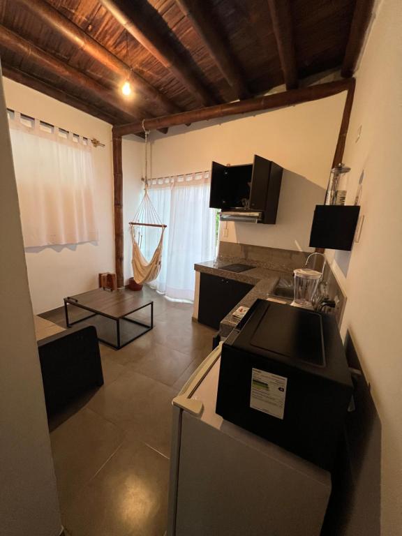 Habitación con cocina con fogones y nevera. en Suites Kiwi Montañita, en Montañita