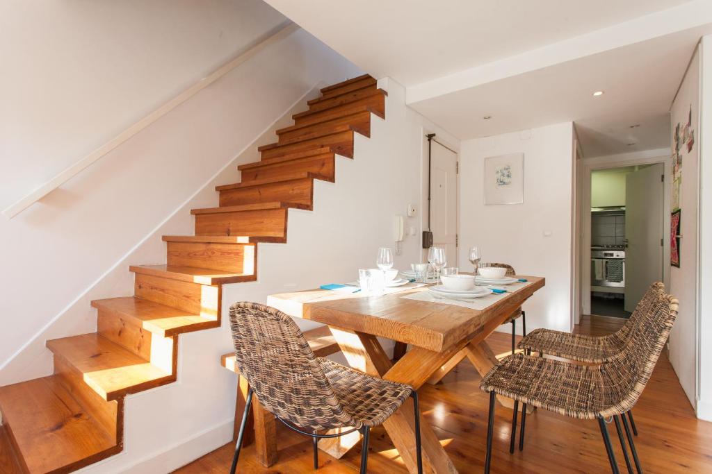 a dining room with a table and chairs and a staircase at FLH Bairro Alto Loft with Sunny Terrace in Lisbon