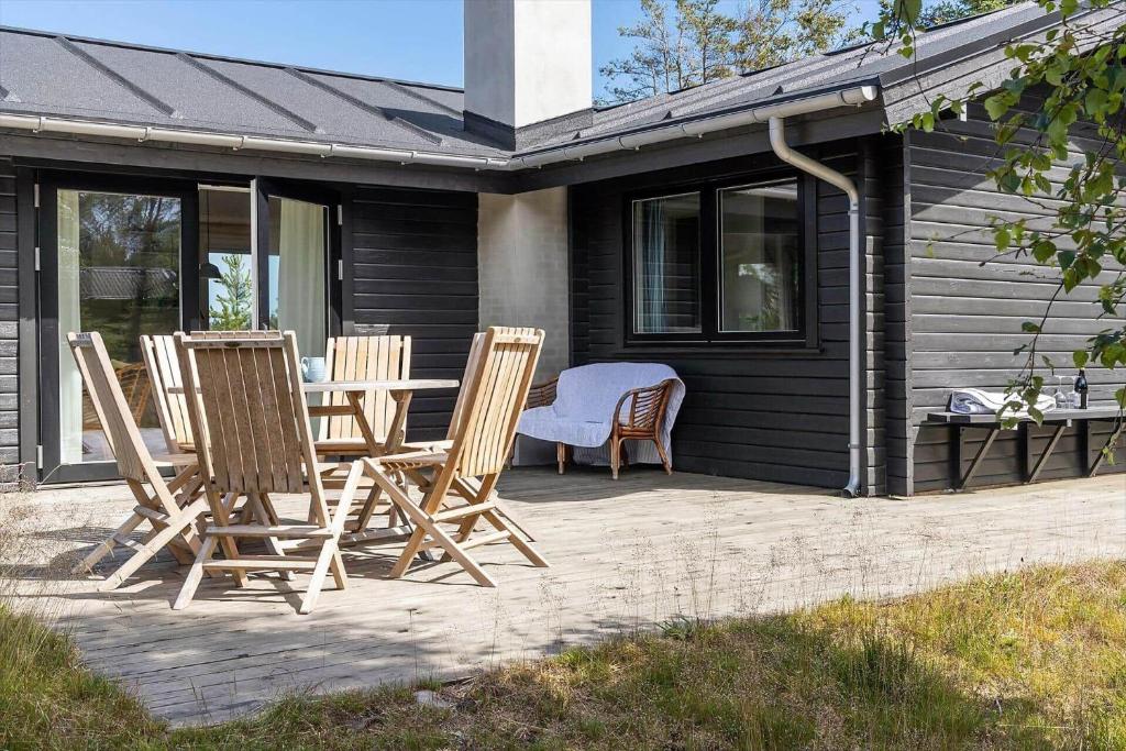 um grupo de cadeiras e uma mesa em um pátio em TV1554-Albaek-Jupitervej-4 em Ålbæk