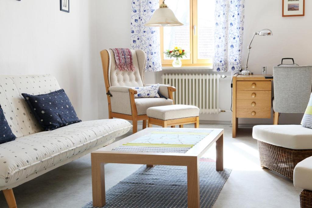 ein Wohnzimmer mit einem Sofa, Stühlen und einem Tisch in der Unterkunft Ferienwohnung Zum Bäckersepp in Neuschönau
