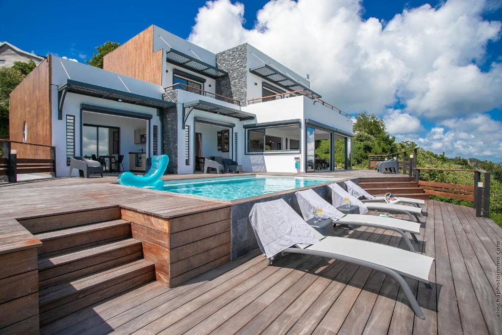 a house with a swimming pool on a wooden deck at Villa de luxe vue exceptionnelle - MQDI92 10p in Le Diamant
