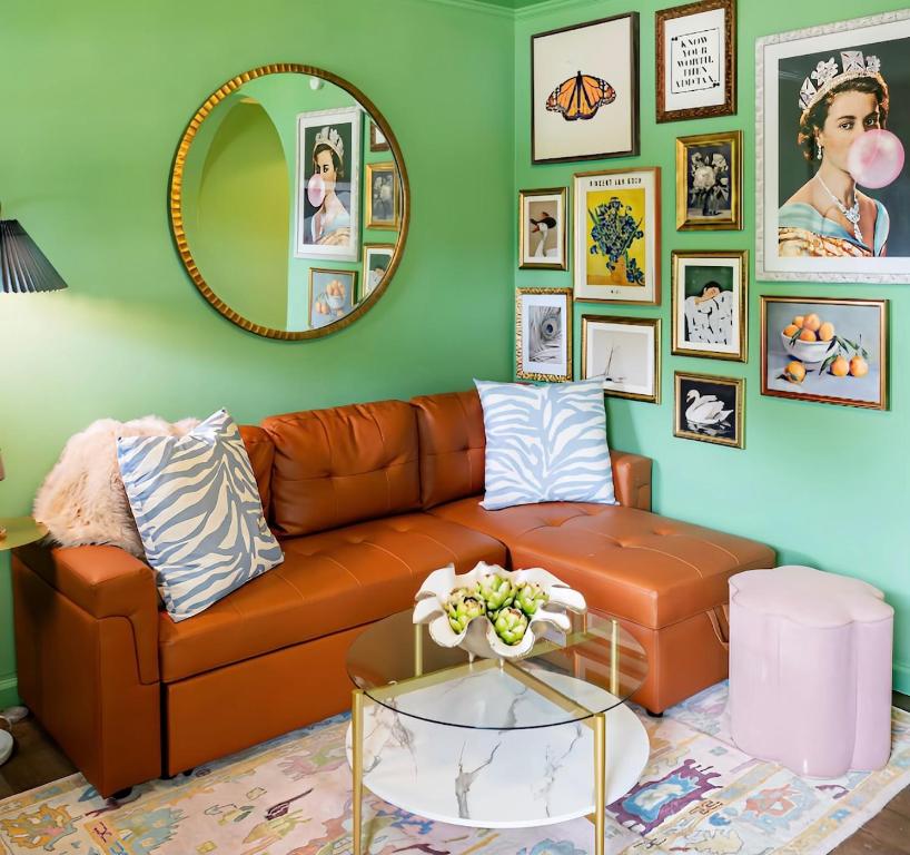 ein Wohnzimmer mit einer braunen Ledercouch und einem Spiegel in der Unterkunft NEW! The Spoonbill House - 2 Kings 1 Full, 10 Minutes to Downtown, 10 minutes to Airport in Charleston