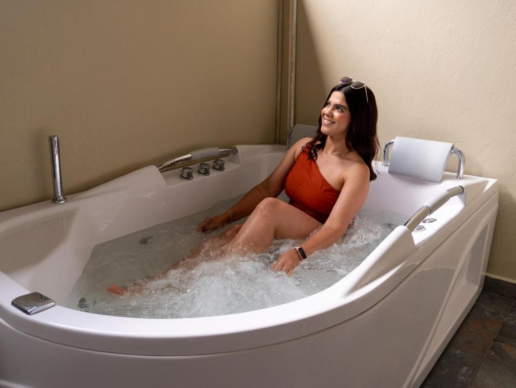 a woman sitting in a bath tub at Hotel Molinos Plaza in Medellín