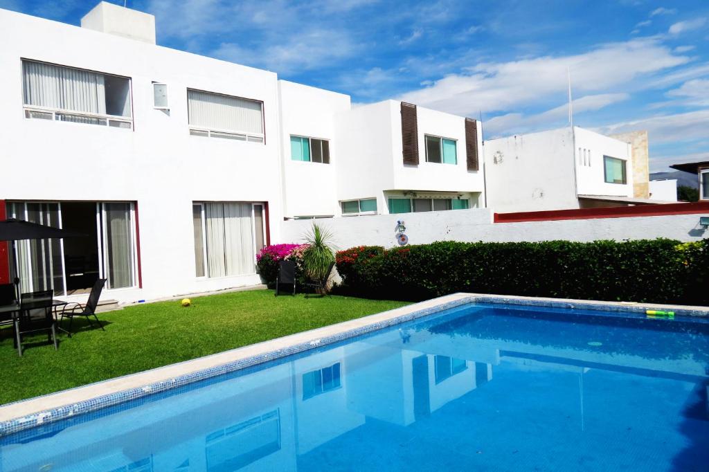 a house with a swimming pool in front of a building at Casa de descanso en Burgos Temixco Morelos in Temixco