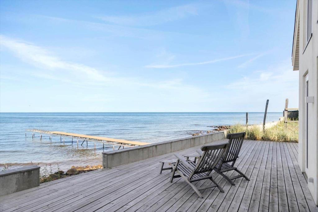 deux chaises assises sur une terrasse face à l'océan dans l'établissement TV1512-Frederikshavn-Saltebakken-50-A, à Frederikshavn