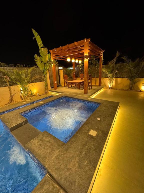 a swimming pool at night with a wooden pergola at EMPIRE-K Homes -Khalid's Villa in New cairo