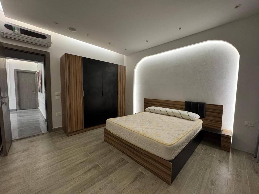 ein Schlafzimmer mit einem Bett in einem Zimmer in der Unterkunft EMPIRE-K Homes -Khalid's Villa in New cairo
